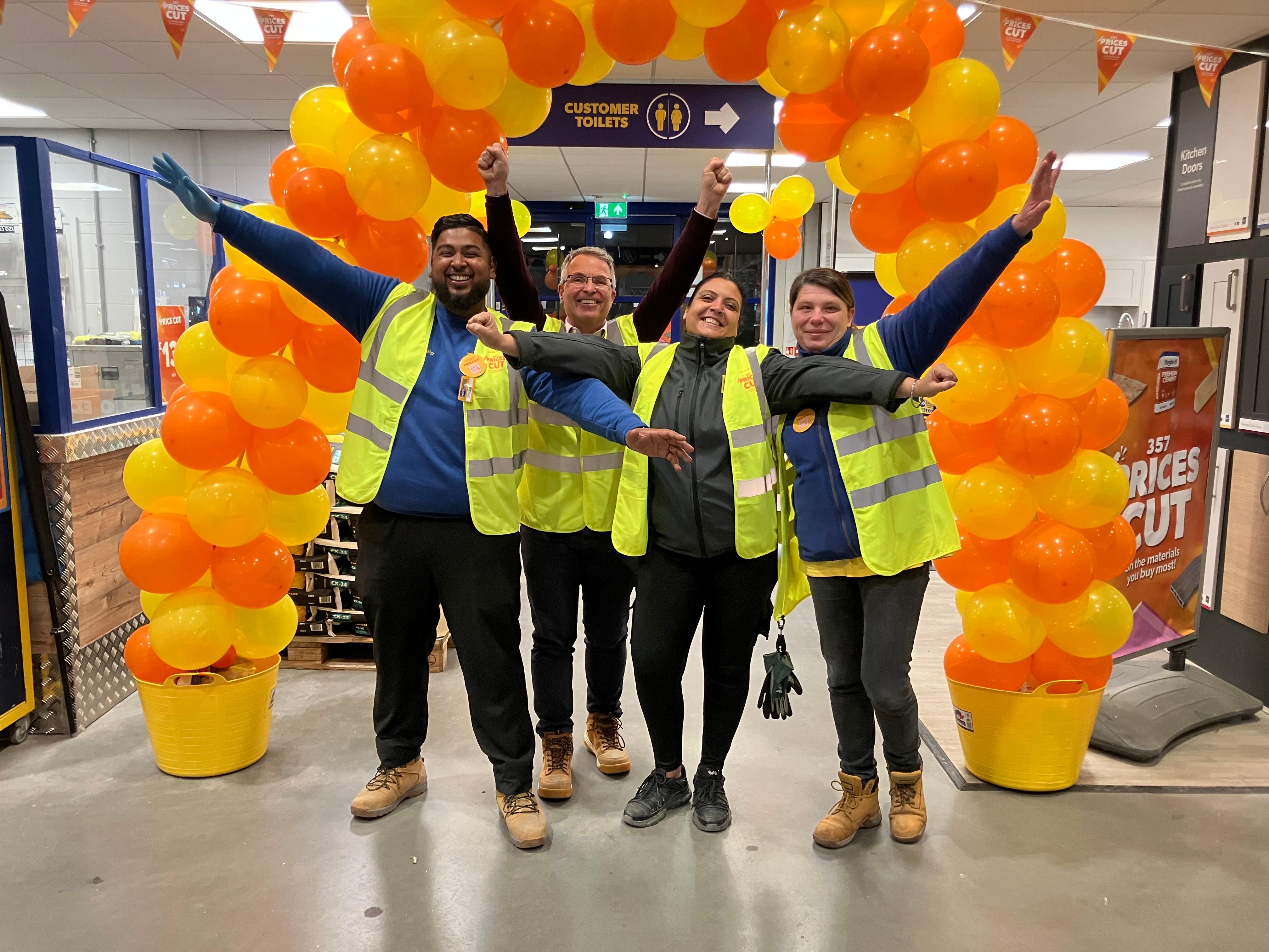 Selco colleagues in store with orange Price Cuts display and balloon arch