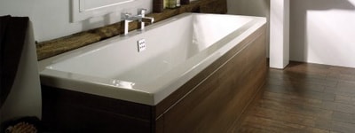 White bath with wooden panel surround