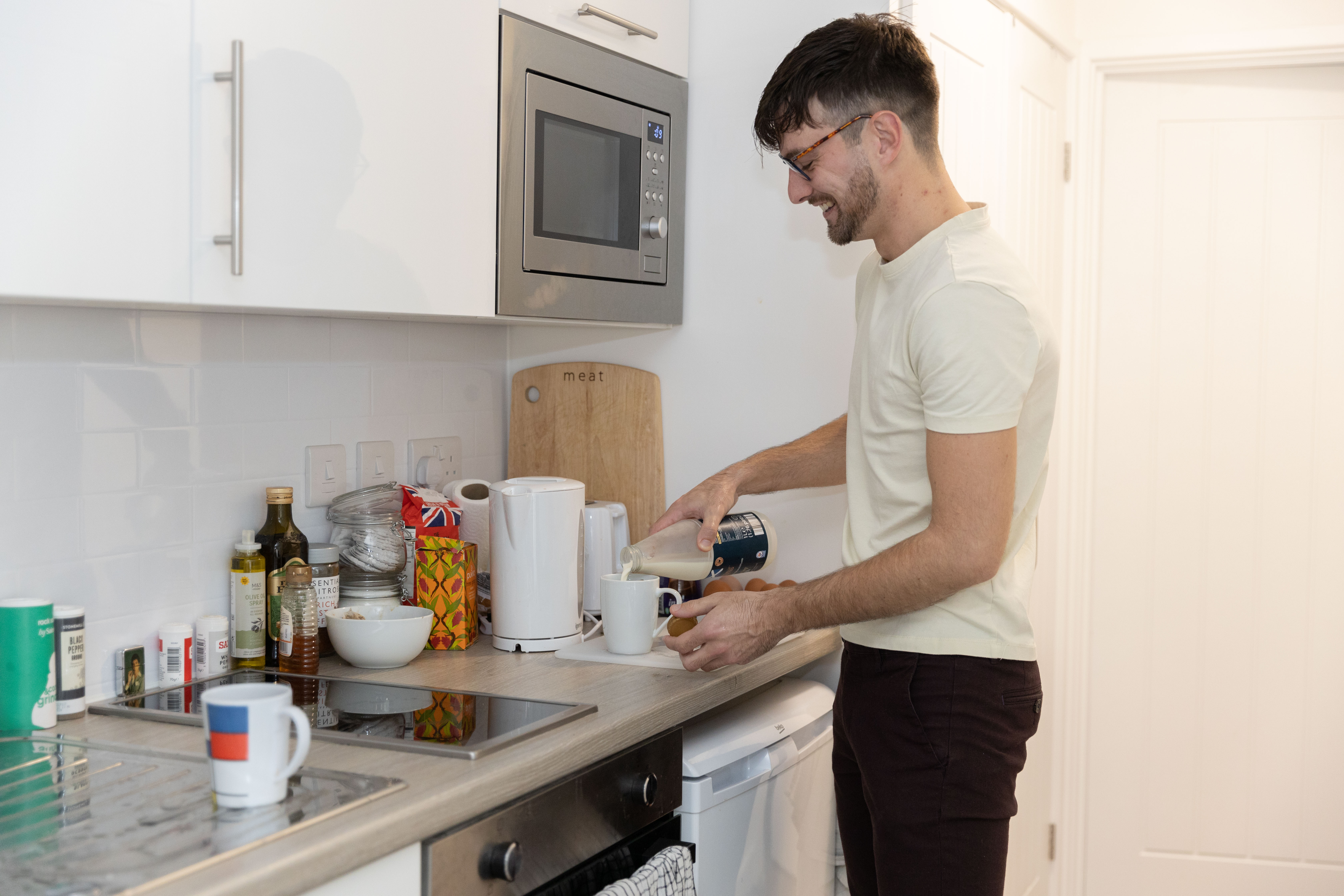Man in kitchen pouring a drink