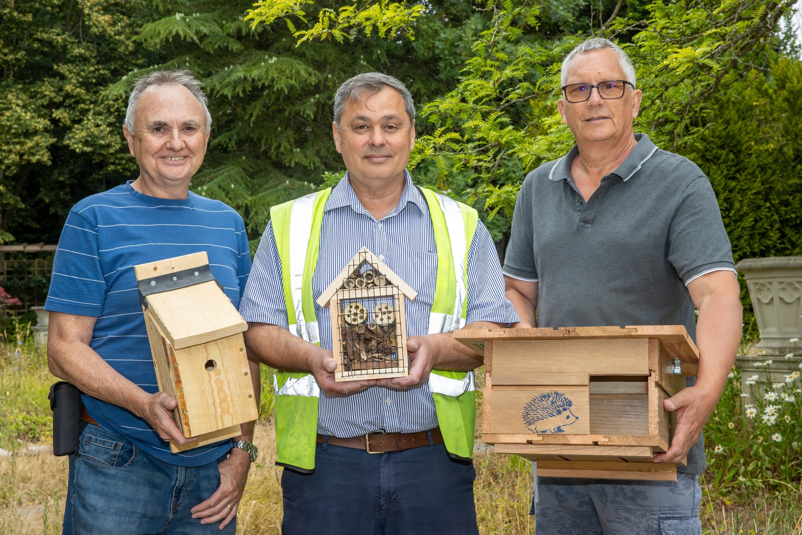 Selco colleagues and Eco Skills Learning Centre colleagues holding bird boxes and bug hotels